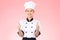 Beautiful Asian chef woman smile and make thumbs up good hand sign  on pink