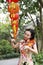 Beautiful Asian Chinese woman artist in traditional chi-pao cheongsam in a garden play violin in on Mid-Autumn Festival lantern