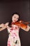 Beautiful Asian Chinese woman in traditional chi-pao cheongsam play violin in a garden pure black background