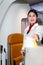Beautiful Asian female cabin crew air hostess gives boarding pass ticket camera at airplane entrance gate, flight attendant checks