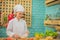 Beautiful asian female chef about to pour sauce on fresh bread in the kitchen full of cooking ingredients