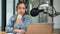 A beautiful Asian female radio host speaks into a microphone, sharing interesting news
