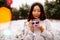 Beautiful asian girl with a cup of coffee stands outdoors in winter park