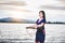 Beautiful Asian girl holding fish trap and basket, prepare to catch fish walking in field near lake