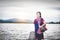 Beautiful Asian girl holding fish trap and basket, prepare to catch fish walking in field near lake