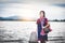 Beautiful Asian girl holding fish trap and basket, prepare to catch fish walking in field near lake