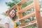 Beautiful Asian girl paiting wooden shelf by roller