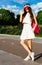 Beautiful asian girl posing on a vintage roller skates in outfit, sneakers and fashionable red Brim Visor Hat on a