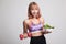 Beautiful Asian healthy girl with dumbbell and salad.