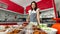 Beautiful Asian housewife and shop owner wearing apron preparing Thai style food,  fried fish-paste patty, for sale and ready to
