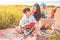 Beautiful Asian mother and son doing picnic and reading tale in red books in Easter summer party on meadow near lake and mountain