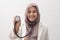 Beautiful Asian muslim female medical doctor wearing hijab want to make examination with stethoscope, smiling to camera