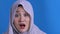 Beautiful Asian muslim woman shocked with mouth opened, frightened to see something bad