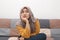 Beautiful Asian muslim woman thinking something seriously while sitting on sofa, girl with contemplation expression