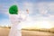 Beautiful asian muslim woman in veil standing and praying with raised arms on the sand