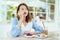 A beautiful Asian portrait is taking a spoonful of cakes on the table and eating them with happy eyes and expressions in the