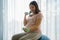 Beautiful Asian pregnant woman doing exercising with dumbbells in living room at home