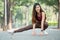 Beautiful Asian sport woman stretching right legs on road of park or garden also smile from relaxation after exercise in the