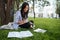 Beautiful asian student keeping records in paper notebook while