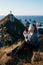 Beautiful asian tourist chilling out at Nugget Point, Dunedin, New Zealand. Young asian traveller enjoys coffee in morning at