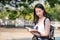 Beautiful asian tourist woman reading the travel guide book searching for for tourists sightseeing spot