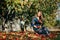 Beautiful asian woman in blue dress picking and smelling red apples in an orchard at Christchruch, New Zealand