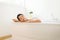 Beautiful asian woman close eye and relax on jacuzzi bathtub in the morning,Female lying body in water at hotel,Copy space for tex