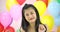 Beautiful asian woman dancing with colorful balloon background at the party in slow motion.