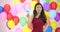 Beautiful asian woman dancing with colorful balloon background at the party in slow motion.