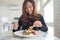 Beautiful asian woman enjoy eating fruits salad on the table in restaurant