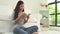 Beautiful asian woman enjoying time and sitting on modern sofa in front of window relaxing in her living room reading book.