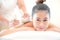 A beautiful Asian woman is laid back and relaxing, the masseuse uses a hot herbal compress in a spa shop