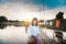 Beautiful Asian woman in local dress holding fishing trap standing and enjoy on bamboo bridge in rice field with decoration on pa