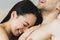 Beautiful asian woman lying on breasts of smiling boyfriend