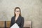 A beautiful Asian woman sits on a wooden chair while waiting for an interview with the company`s human resources committee,