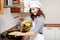 Beautiful Asian woman in white chef hat preparing an omelet in the kitchen.