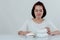 Beautiful Asian woman, white shirt Sitting in front of the dining table There is an expression of disgust in the foam box. Do not