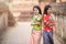 Beautiful Asian women hold plastic water guns at an ancient temple during Songkran, the most beautiful and fun water festival in