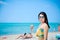 Beautiful Asian women wearing black sunglasses and colorful swimwear on the beach