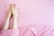 Beautiful Asian Young Woman Body Legs and Feet Isolated on The Pastel Pink Bedroom Background. Female Foot in Bed Sleep Relax.