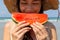 Beautiful asian young woman looks at watermelon for eating in summer season at beautiful beach in hot weather that make beautiful