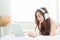 Beautiful asian young woman relax listening to music with headphone and laptop online internet on vacation in bedroom.