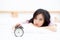 Beautiful asian young woman turn off alarm clock in morning, wake up for sleep with alarm clock, relax and lifestyle concept.