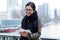 Beautiful asian young woman using her digital tablet in front of Seine river in Paris.