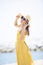 Beautiful asian younger woman wearing  yellow dress relaxing on summer vacaiton beach