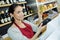 Beautiful assistant taking credit car customer in wine store