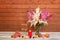 Beautiful astilbe flowers, burning candle, champagne and fresh fruits on aged wooden table