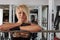 Beautiful athlete blonde woman posing in power rack