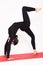 Beautiful athletic girl in black suit doing yoga. chakrasana - bridge pose. Isolated on white background.