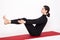 Beautiful athletic girl in black suit doing yoga. naukasana asana - boat pose. Isolated on white background.